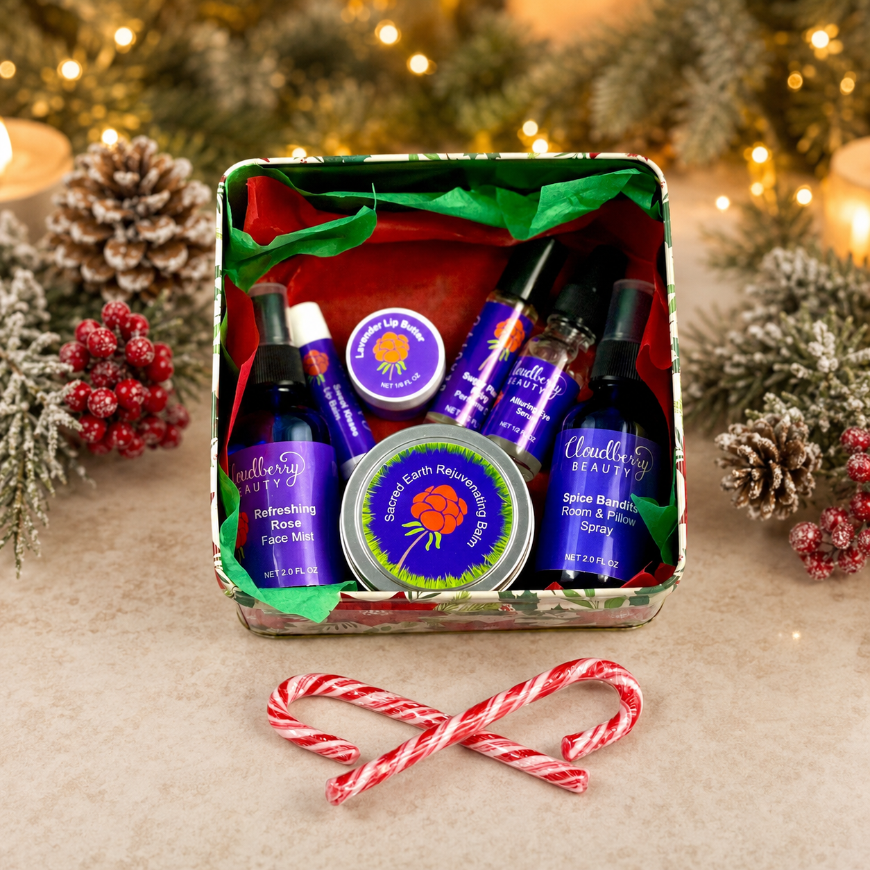 Open Christmas gift tin filled with assorted Cloudberry Beauty skincare products, greenery and candy canes.