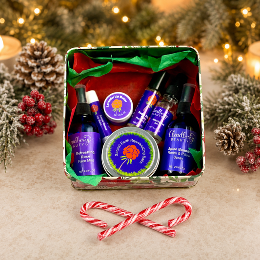 Open Christmas gift tin filled with assorted Cloudberry Beauty skincare products, greenery and candy canes.
