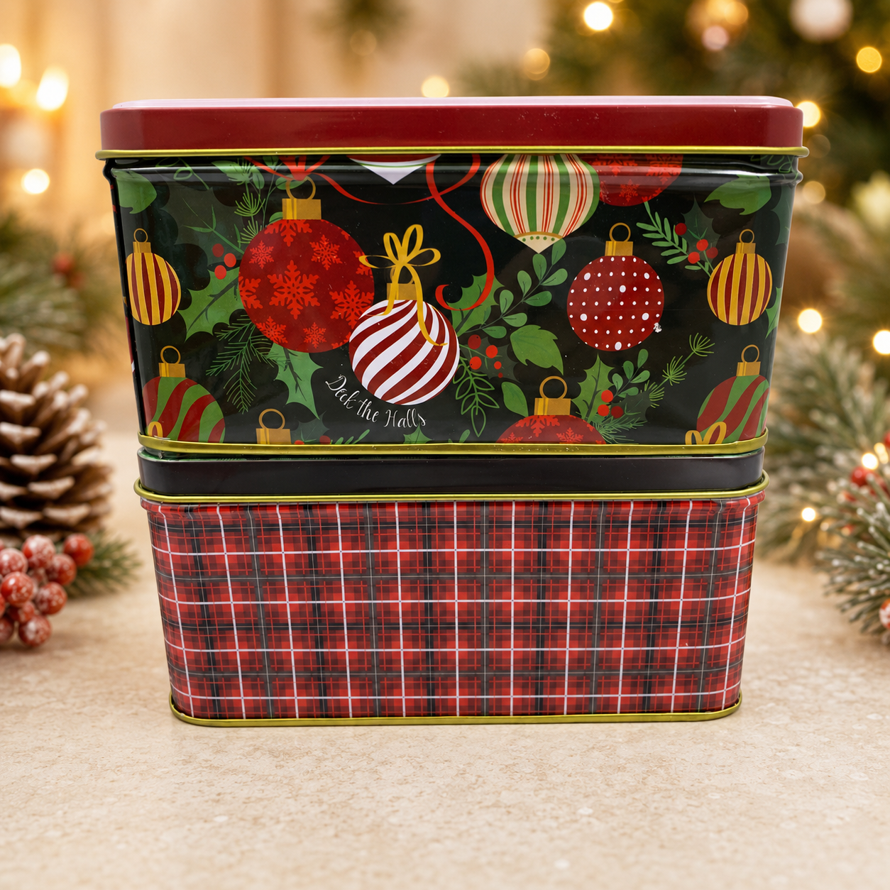 Two stacked Christmas gift tins featuring colorful ornament and red plaid designs.