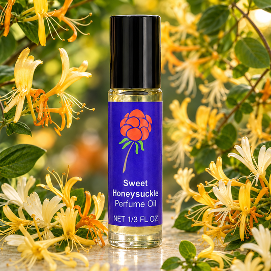 Close-up of Cloudberry Beauty Sweet Honeysuckle Perfume Oil roll-on bottle surrounded by yellow and white honeysuckle blossoms.